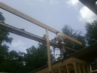 Carpenter setting a ridge beam over a new addition frame — Ice Dam Removal by Roofing Brothers in Merino