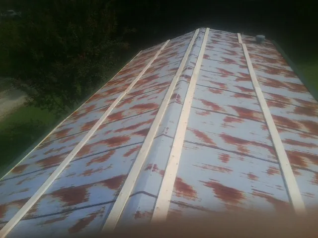 Rusted metal roof panels with new wood purlins before replacement — Storm Damage Roof Repair in Merino by Roofing Brothers